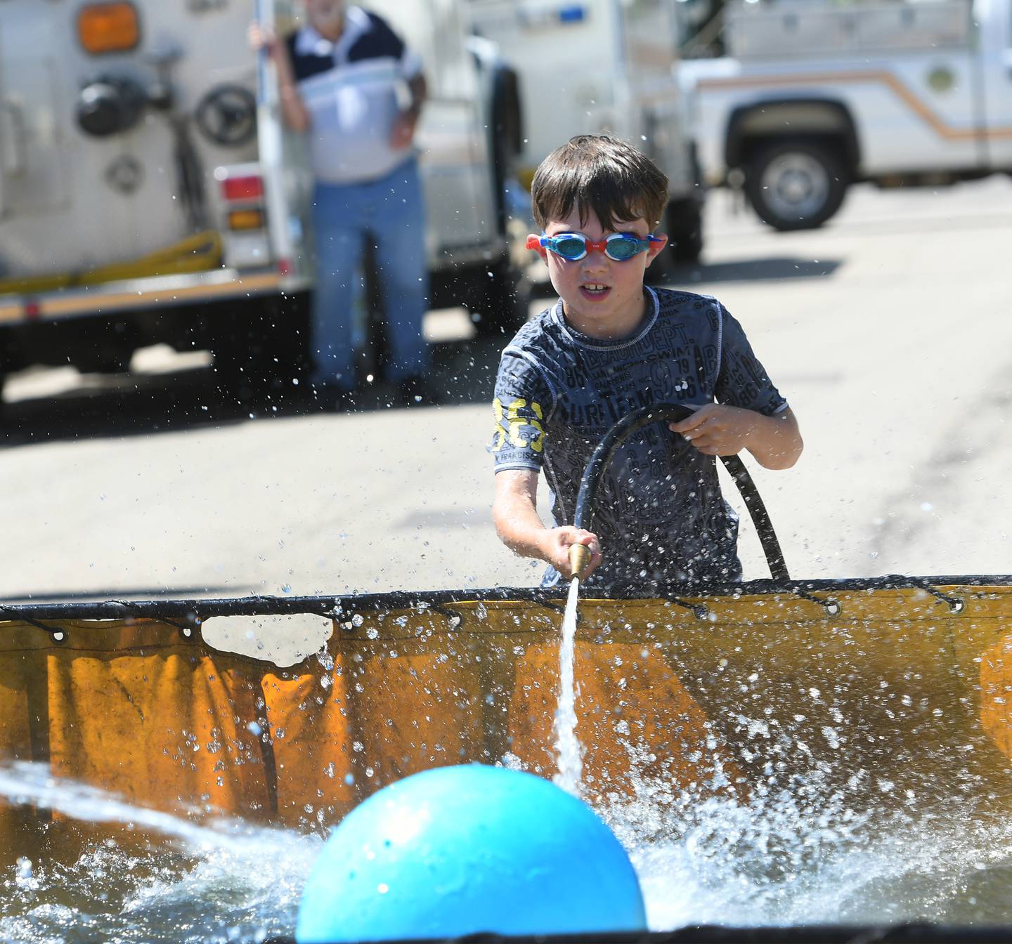 Trent Jordan, 10, of Chadwick, sprays water on a plastic ball during the kids' water fights during Polo's Town & Country Days on June 18, 2022. Trent's dad, Health, is a firefighter for Chadwick and was competing in the Polo Fire Department's Water Fights later that day.