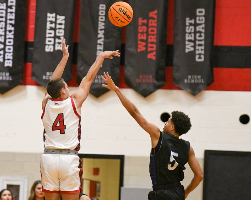Glenbard East's Michael Nee (4) takes a shot while being defended by Riverside Brookfield's Cameron Mercer (5) during the game on Friday Dec. 19, 2025, held at Glenbard East High School.