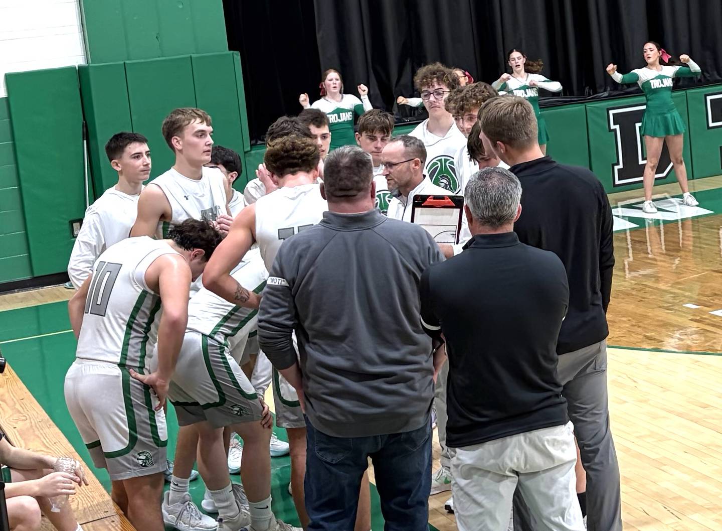 Dwight boys basketball coach Jeremy Connor (at center) talks things over with his Trojans during a second-half timeout Friday, Feb. 13, 2026, in Dwight.