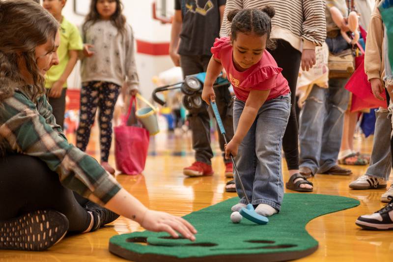 Kaia Lindell plays mini golf at the annual Easter Egg hunt on Saturday, April 12, 2025 at Hall High School in Spring Valley.