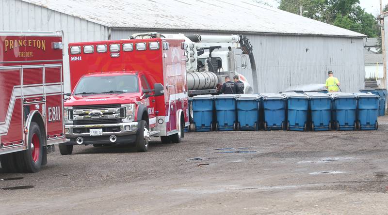 Princeton Fire and EMS help City of Princeton workers wash down and load new garbage totes onto trucks at the city dump on Monday, April 29, 2024 in Princeton. The city of Princeton is transitioning from the old-style ride-on garbage trucks to the new side-load truck equipped with a robotic arm.