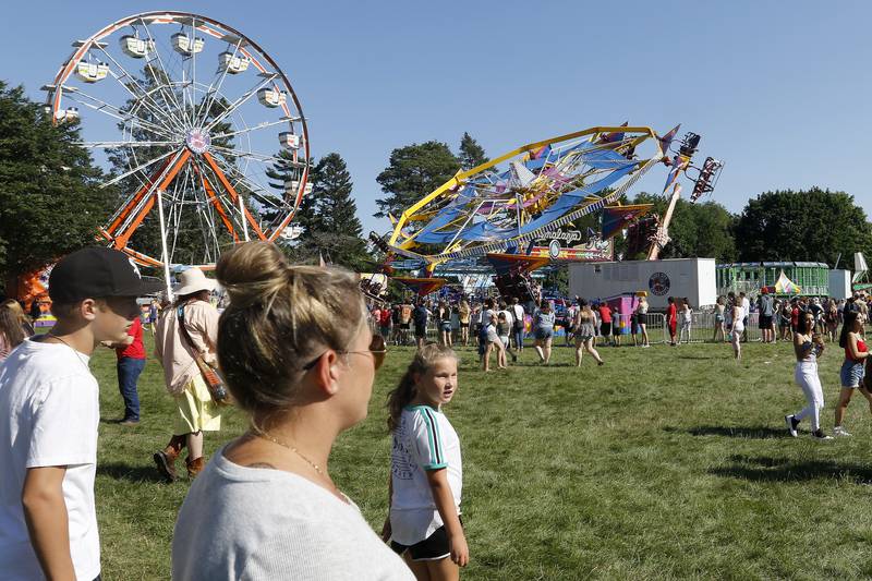 Attendees filter into the carnival during the annual Lakeside Festival at the Dole and Lakeside Arts Park on Thursday, July 1, 2021, in Crystal Lake.
