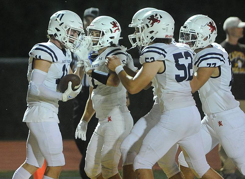 St. Viator's Michael Nix celebrates his touchdown against Carmel on a pass play with his teammates in the varsity football matchup at Carmel High School on Friday.