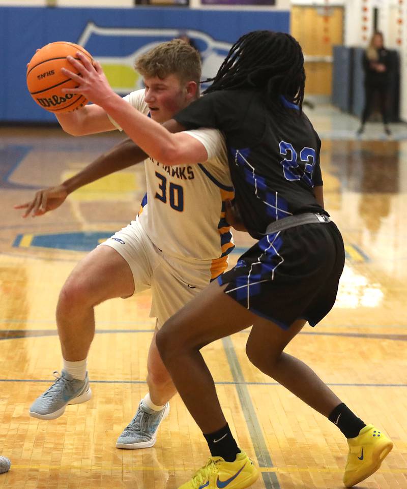 Johnsburg's Jayce Schmitt tries to drive to the basket against Woodstock's Marc Thomas during a Kishwaukee River Conference boys basketball game on Friday, February. 13, 2026, at Johnsburg High School.