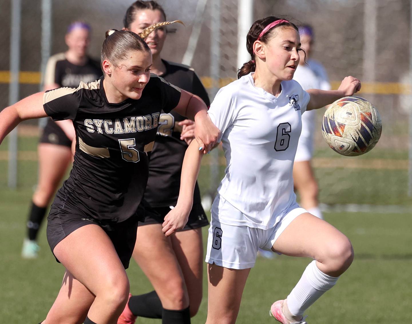 Sycamore's Grace Amptmann and Kaneland's Taylor Mills go after a ball in the air during their game Monday, April 14, 2025, at Sycamore High School.