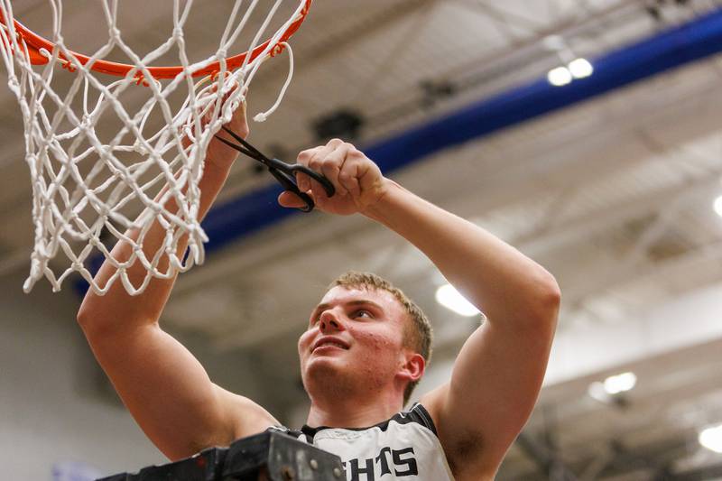 Kaneland's Jake Buckley cuts a piece of net after the win over Burlington Central at the Class 3A Burlington Central Regional Final on Friday, Feb. 27,2026 in Burlington.