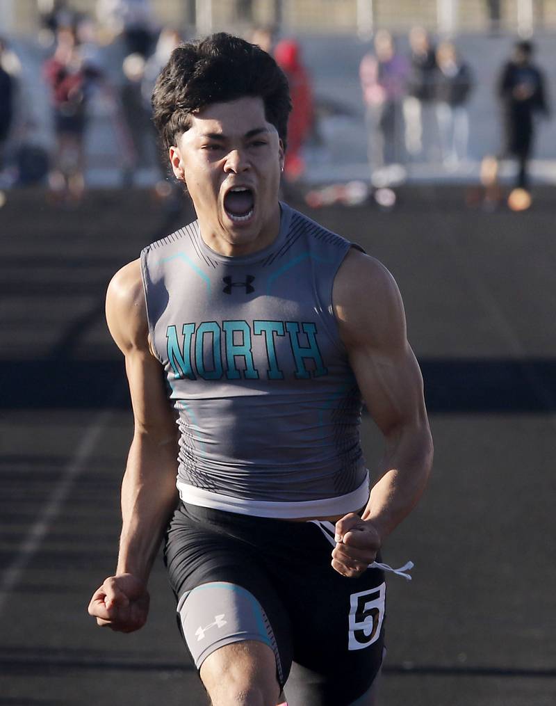 Woodstock North's Adan Castaneda celebrates winning the 100 meter dash over North Chicago’s Marlin Jeffries Jr. during the IHSA Class 2A Richmond-Burton Sectional Boys Track and Field Meet on Wednesday, May 20, 2026, at Richmond-Burton High School.