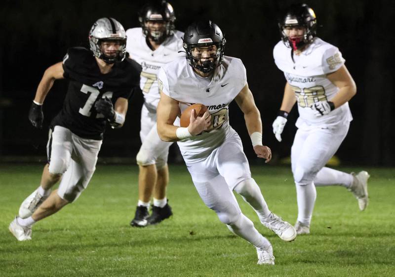 Sycamore's Burke Gautcher scrambles away from the Kaneland pass rush during their game Friday, Oct.4, 2024, at Kaneland High School in Maple Park.