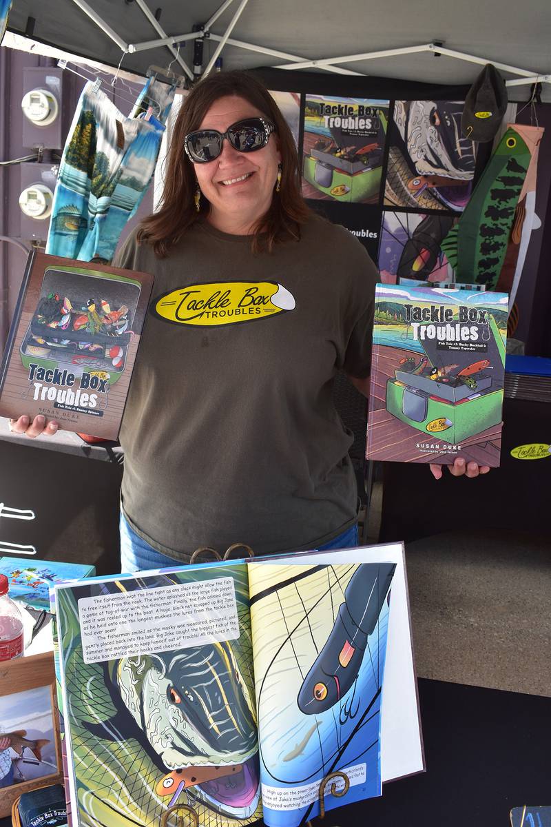 Retired special education teacher and author Susan Duke of Fox River Grove showcases her new book at the Tackle Box Trouble booth during Amboy's Depot Days on Sunday, Aug. 24, 2025.