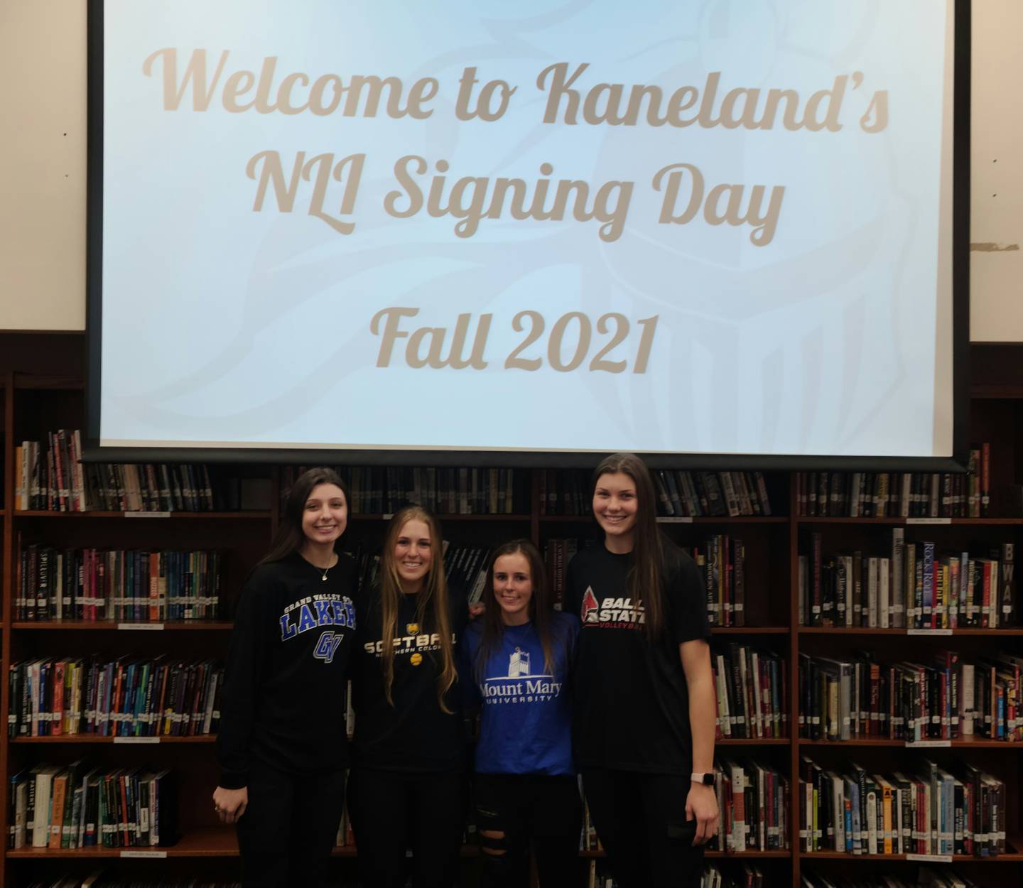 Kaneland volleyball player Megan O'Sullivan, softball players Grace Algrim and Taylor Hames, and volleyball player Madison Buckley pose at a signing day ceremony Wednesday, November 10.