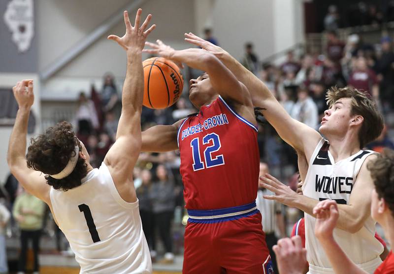 Dundee-Crown's Anthony Spain has th ball knocked away as her drives to the basket between Prairie Ridge's Luke Vanderwiel (left) and Maddon McKim (right) during a Fox Valley Conference boys basketball game on Friday, Jan. 16, 2026, at Prairie Ridge High School in Crystal Lake.