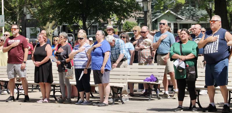 A portion of the more than 120 in attendance stand with hands on hearts during the Pledge of Allegiance during a Memorial Day observance on Monday, May 29, 2023, at Grandon Civic Center in Sterling.