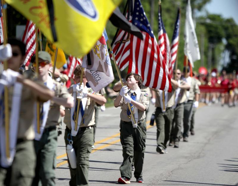 Members of Boy Scout Troop 23 in Wheaton carry flags along Warrenville Road in Wheaton for the annual Memorial Day Parade on Monday, May 29, 2023.