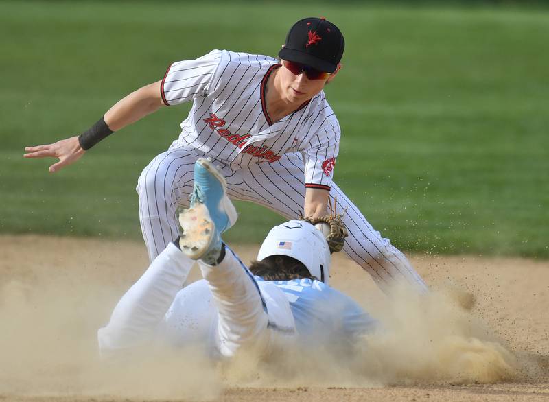 Benet shortstop Ryan Cibulka (top) tags out Nazareth's Cole Reifsteck on an attempted steal of second base during a game on April 22, 2024 at Benet Academy in Lisle.