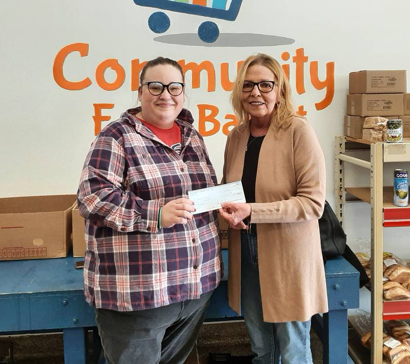 (From left) Marissa Vicich, executive director of the Community Food Basket, accepts a monetary donation and more than 100 pounds of food from Ottawa Moose Lodge 960 President Becky Tirevold.