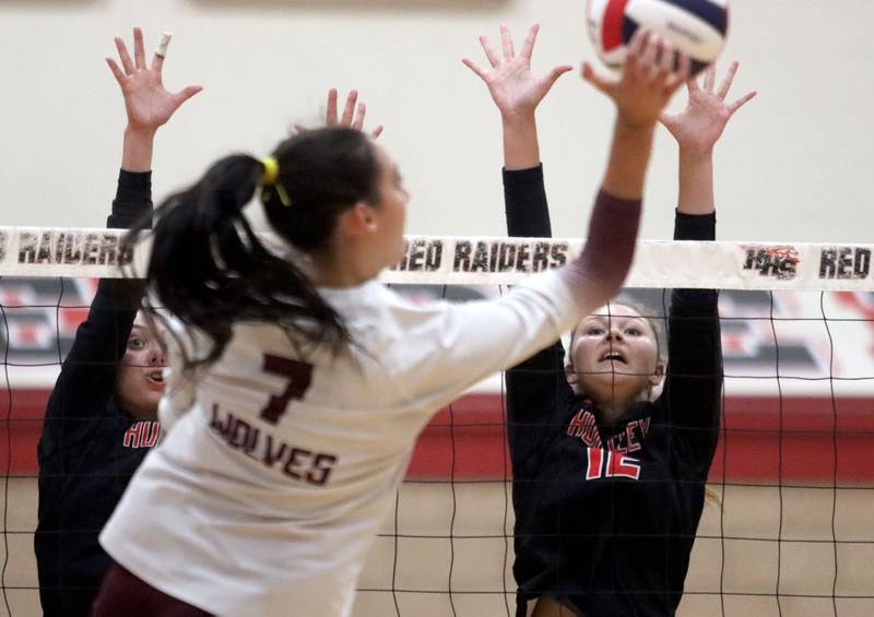 Prairie Ridge’s Maizy Agnello, center, hits the ball as Huntley’s Summer Massow, right, blocks in varsity girls volleyball at Huntley High School in Huntley on Thursday, Sept. 11, 2025.