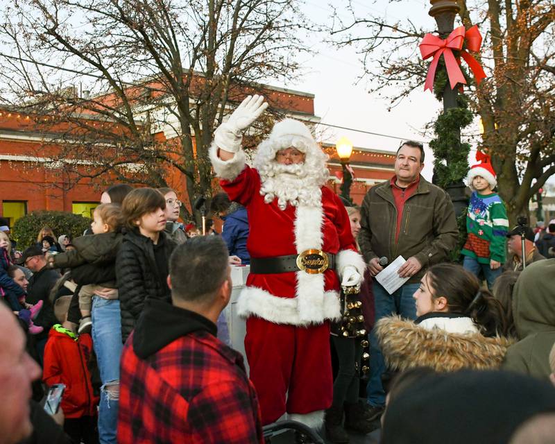 Santa waves to the crowed after Downers Grove Mayor Bob Barnett welcomes him to help with the tree lighting ceremony in downtown Downers Grove near the Main Street station on Friday, Nov. 25, 2022.