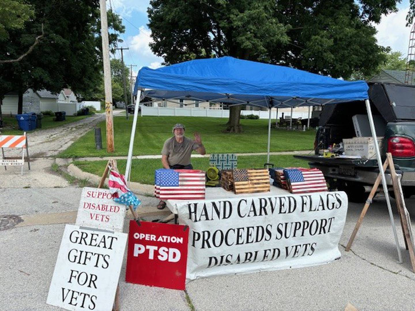 A man selling carved American flags to support disabled veterans.