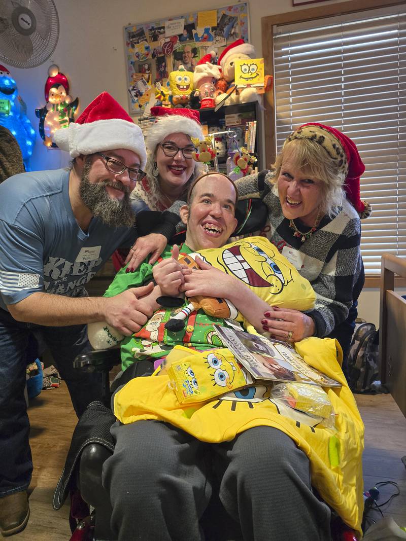 Marklund Hyde Center resident Chris Hicke is thrilled with his new Sponge Bob-themed gifts. His family assisted with opening his presents during Marklund’s annual Christmas Eve gift opening event.