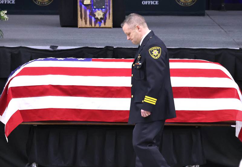 DeKalb County Sheriff Andy Sullivan bows his head as he approaches the flag-draped casket of colleague Deputy Christina Musil Thursday, April 4, 2024, during her visitation and funeral in the Convocation Center at Northern Illinois University. Musil, 35, was killed March 28 while on duty after a truck rear-ended her police vehicle in Waterman.