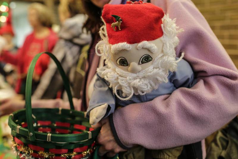 Kristi Dziura holds a gnome doll as she shops the market Saturday at Festival of Gnomes at Bicentennial Park in Joliet.