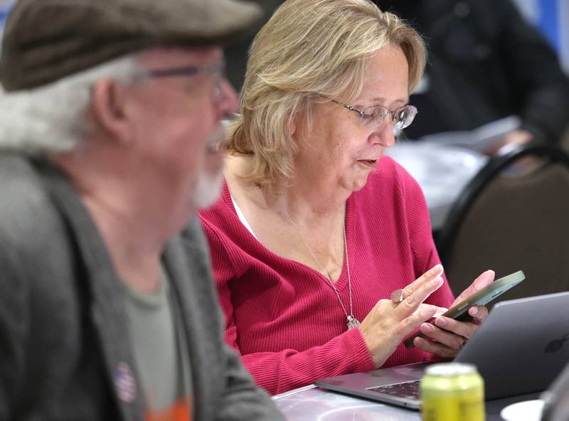 Randi Olson, Democratic candidate in the 70th District state representative race, keeps updated by phone and computer as DeKalb County Board candidate Stewart Ogilvie looks on Tuesday, Nov. 5, 2024, at the election night watch party at River Heights Golf Club in DeKalb.