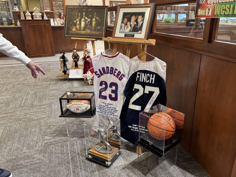 A signed University of Illlinois football, a signed Chicago Bulls Basketball, a signed Jenny Finch jersey, a signed Ryne Sandburg jersey and more are available for the 2025 Operation St. Nick Radio Auction. Photo taken on Tuesday, Nov. 25, 2025.
