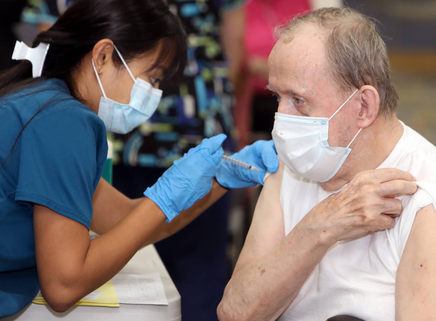 Timbers of Shorewood resident John Bazzoni receives the COVID-19 booster vaccine from Saint Francis College of Nursing student Lorimel Edquid during a vaccine clinic held at Timbers of Shorewood Friday, October 8, 2021, in Shorewood, Ill.