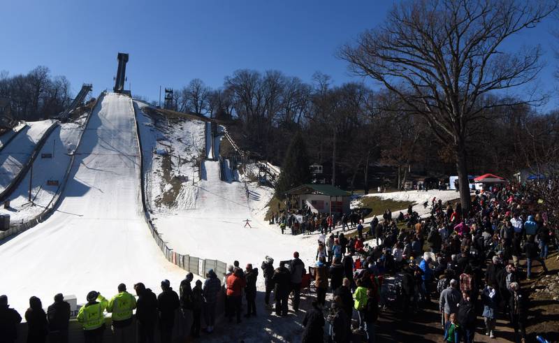 Spectators watch competitors during opening day of the Norge Ski Club’s 118th annual Winter Ski Jump Tournament Saturday.