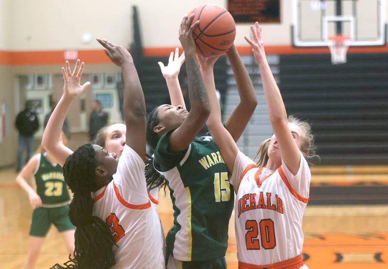 Waubonsie Valley's Taylor Curry grabs a rebound between two DeKalb defenders during their game Thursday, Dec. 15, 2022, at DeKalb High School.
