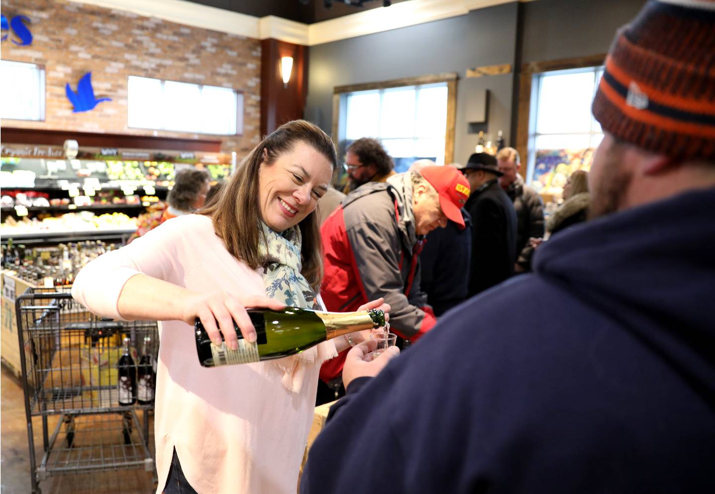 Elizabeth Schuster pours wine during the final wine tasting event at Blue Goose Market in St. Charles on Thursday, Feb. 24, 2022. The store is closing after 90 years in business.