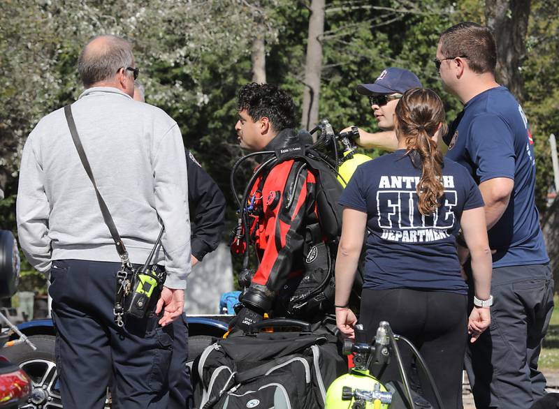 A diver reprts what he found after a search while divers from the Antioch Fire Protection District and a sonar team from the Illinois Department of Natural Resources continue searching Tuesday, Oct. 7, 2025, on Fox Lake near Antioch for a man thrown from a boat he was test driving Monday night.
