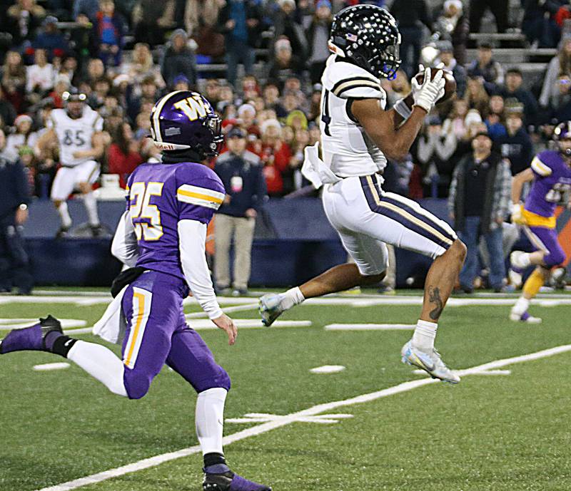IC Catholic's KJ Parker (14) makes a catch over Williamsville's Joshua Cates (25) in the Class 3A State title game on Friday, Nov. 25, 2022 at Memorial Stadium in Champaign.