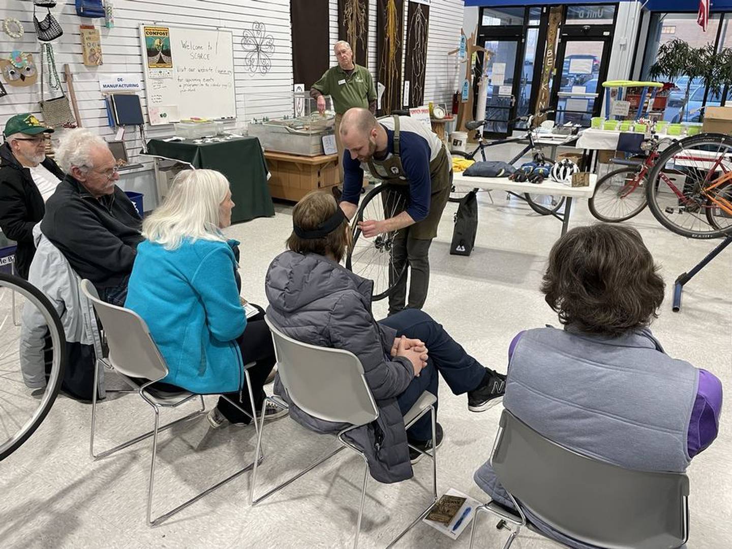 Alex Lamers of Working Bikes, a nonprofit bike repair shop in Chicago, shows participants how to identify a leak in a bicycle tire. (Photo courtesy of SCARCE)