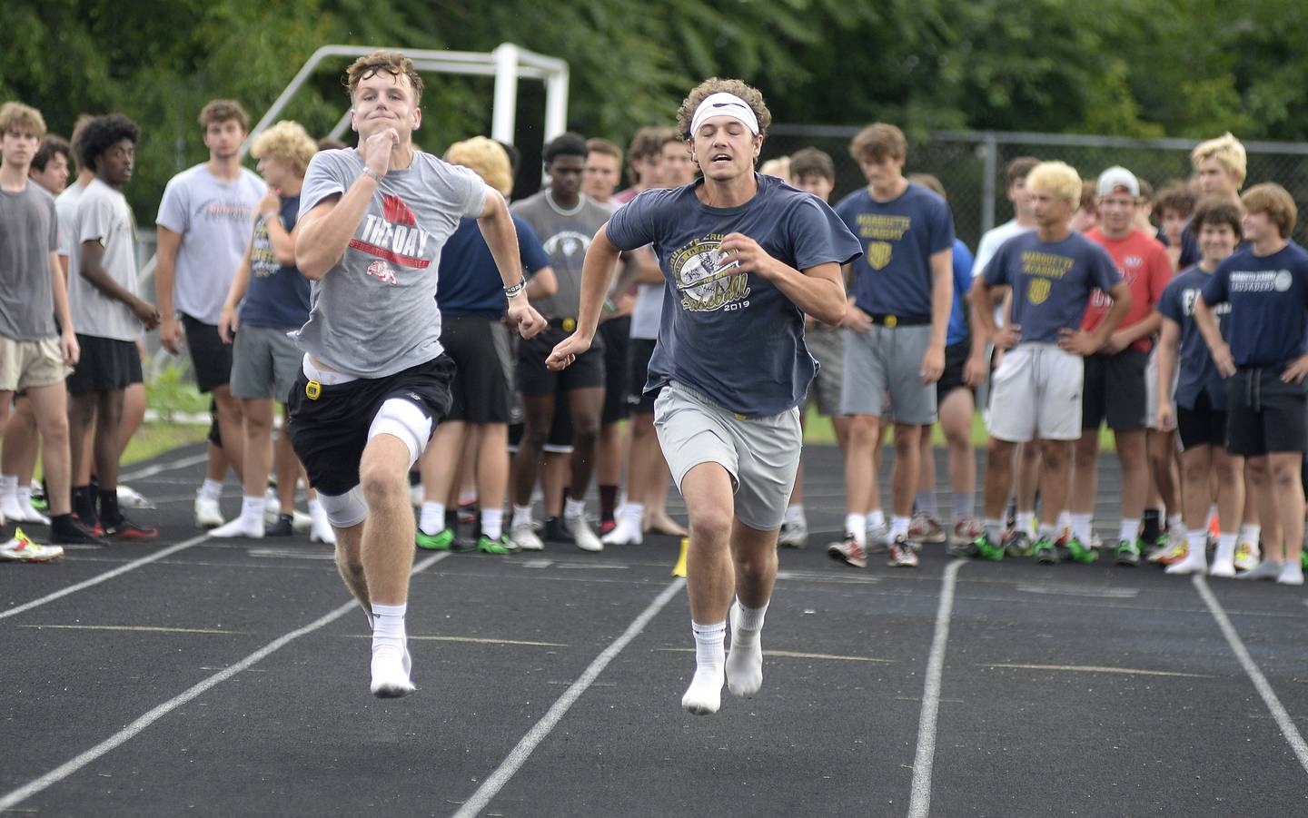 Streator's Liam Martin (left) and. Marquette's Vinny Battistelli race while their teammates look on Monday, July 11, 2022, during the teams' joint practice/7-on-7 at the SHS Athletic Fields.