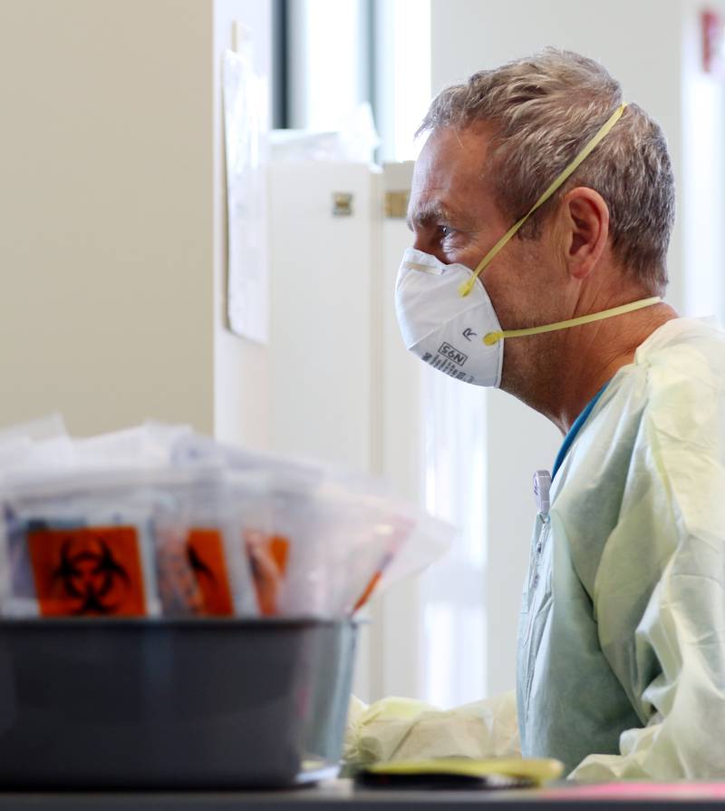 Immediate Care Technician Randy Uidl waits to swab drive-thru patients for COVID-19 at the Northwest Medicine Huntley Hospital campus on Wednesday, June 23, 2021, in Huntley.