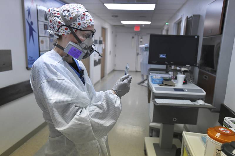 Wearing layers of protective gear, RN Taylor Perri prepares her equipment tray for the next patient as she works in the COVID-19 ward at UF Health's downtown in Jacksonville, Fla., campus Friday, July 30, 2021. The second surge of COVID-19 infections in Jacksonville is stretching the capacity of area medical facilities to care for patients.