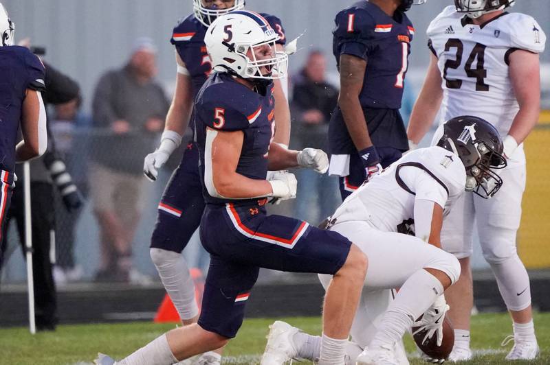 Oswego’s Carson Cooney (5) reacts after tackling Joliet Catholic's Nate Magrini (right) during a football game at Oswego High School.