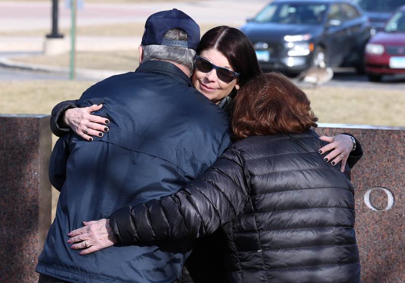 Northern Illinois University President Lisa Freeman hugs Larry Gehant and Charlotte Schiller, aunt and uncle of shooting victim Julianna Gehant, Wednesday, Feb. 14, 2024, during a ceremony in the Peaceful Reflection Garden near Cole Hall honoring the victims of the 2008 shooting at NIU in DeKalb. Wednesday marked 16 years since the deadly shooting took place on campus which took the lives of five people.