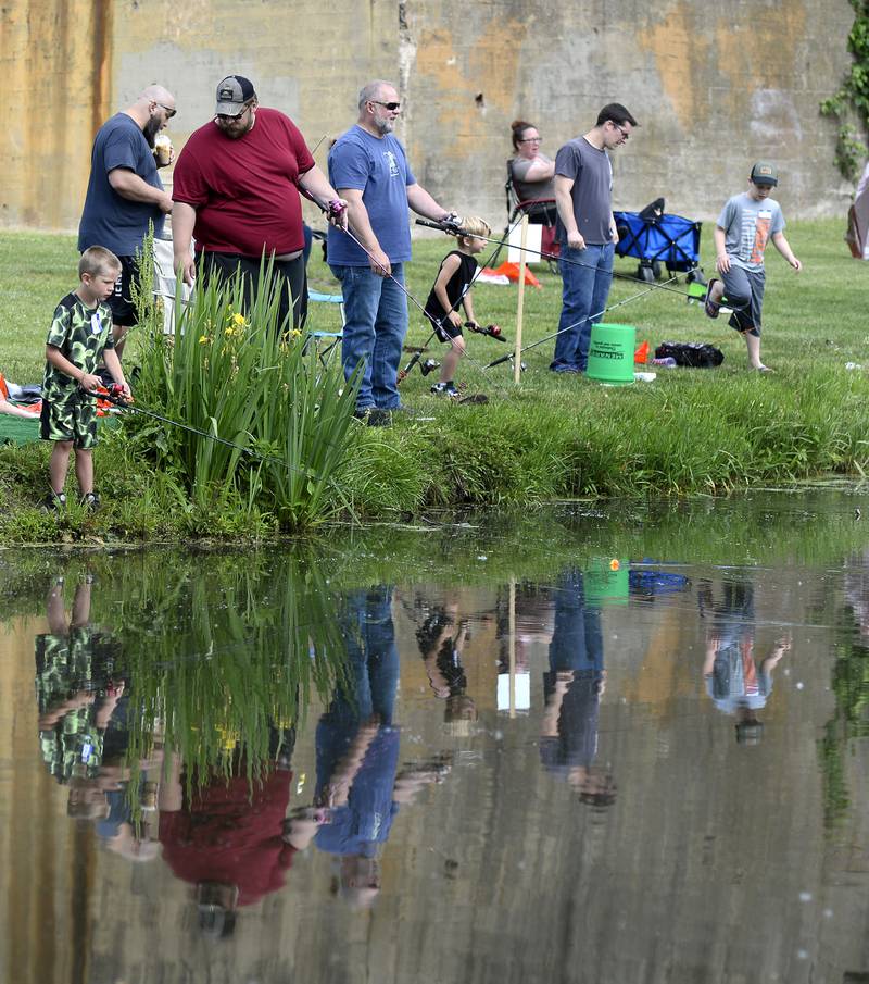 Anglers are reflected in the canal at Lock 14 as they compete Saturday, June 4, 2022, in the annual Kids Fishing Tournament in La Salle.