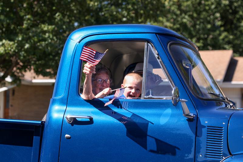 Parade participants wave American flags from inside a vintage Ford during the 104th annual Herscher Labor Day Celebration Grand Parade on Monday, Sept. 1, 2025.