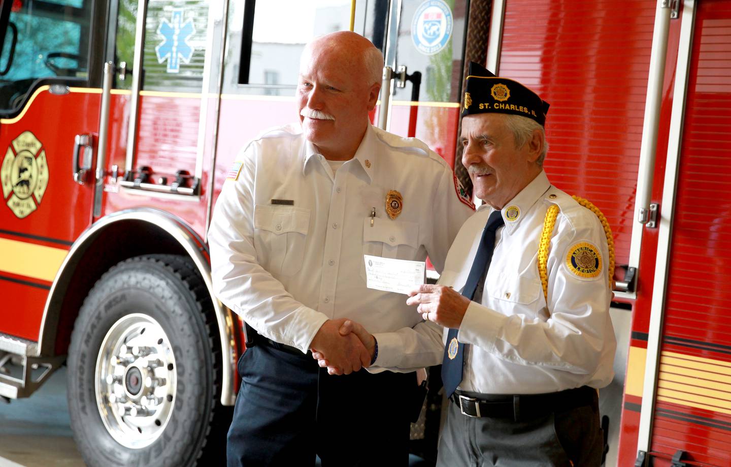 St. Charles Fire Chief Scott Swanson (left) accepts a check from American Legion Post 342 Commander Joe Morgan, Sr. Donations were collected by the VFW, American Legion, AMVETS and Vietnam Veterans of America and used for a training mannequin for the St. Charles Fire Department.