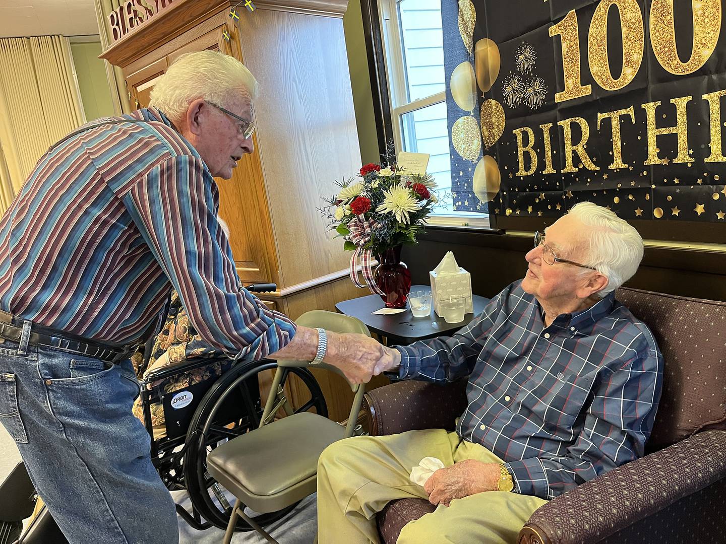 Jim O’Connell congratulates Dave Werdin as he celebrates his 100th birthday at a party in Kaneville on Saturday, Sept. 21, 2024.