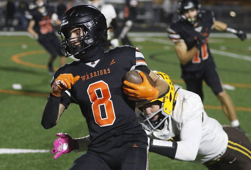 McHenry's Jeffry Schwab is tackled by Jacobs' Matthew Scardina during a Fox Valley Conference football game on Friday, Oct. 18, 2024, at McCracken Field in McHenry.