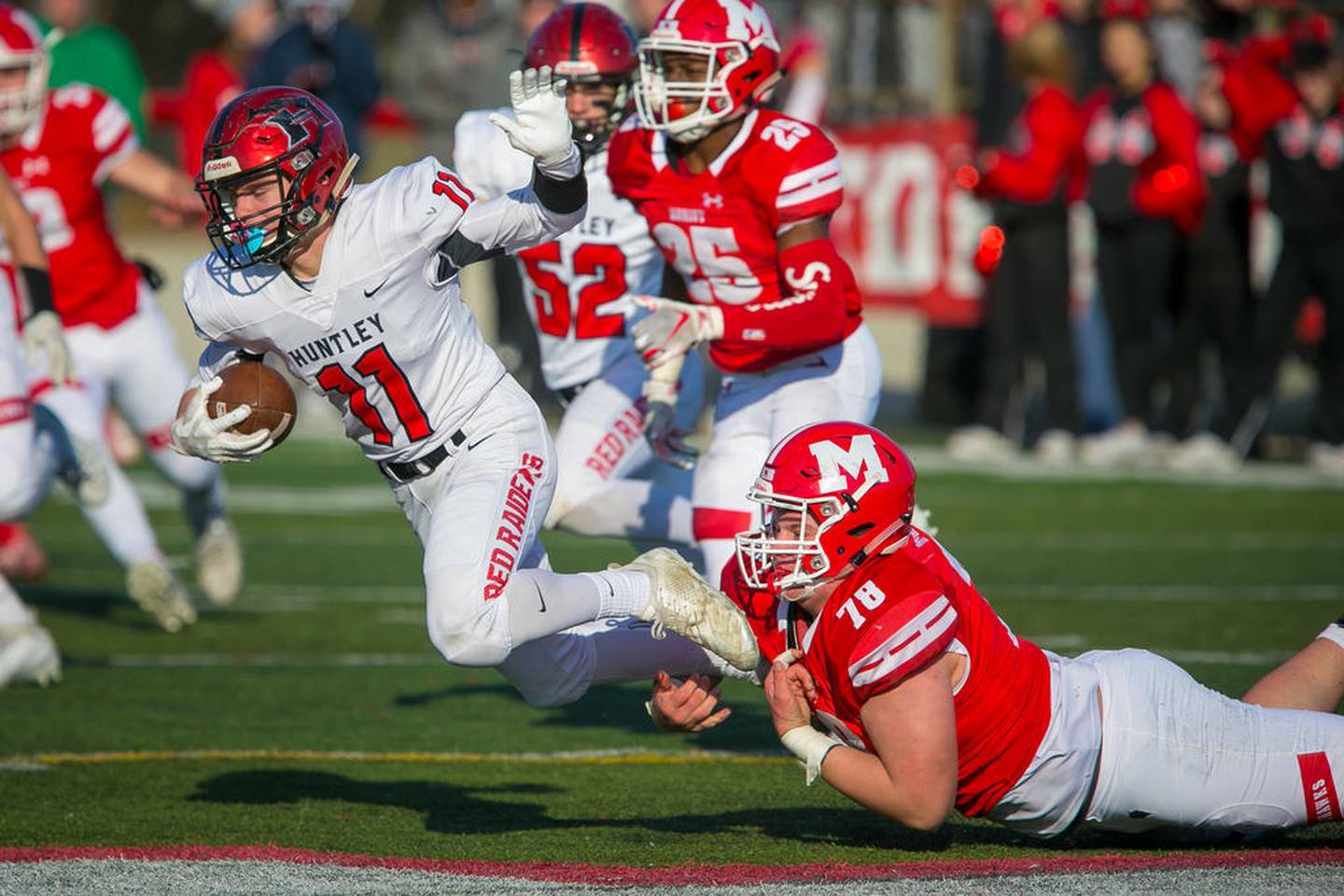 Huntley punt returner Alex Janke is tripped up by Marist lineman Pat Coogan during the third quarter Saturday in their Class 8A second-round game in Chicago.