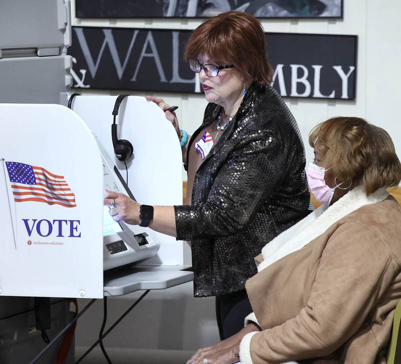 Election Judge Tamara Person-Hescott shows Patricia Doss, of DeKalb, how to use one of the new touch screen voting machines on Election Day, Tuesday, Nov. 8, 2022, at the polling place in Westminster Presbyterian Church in DeKalb.