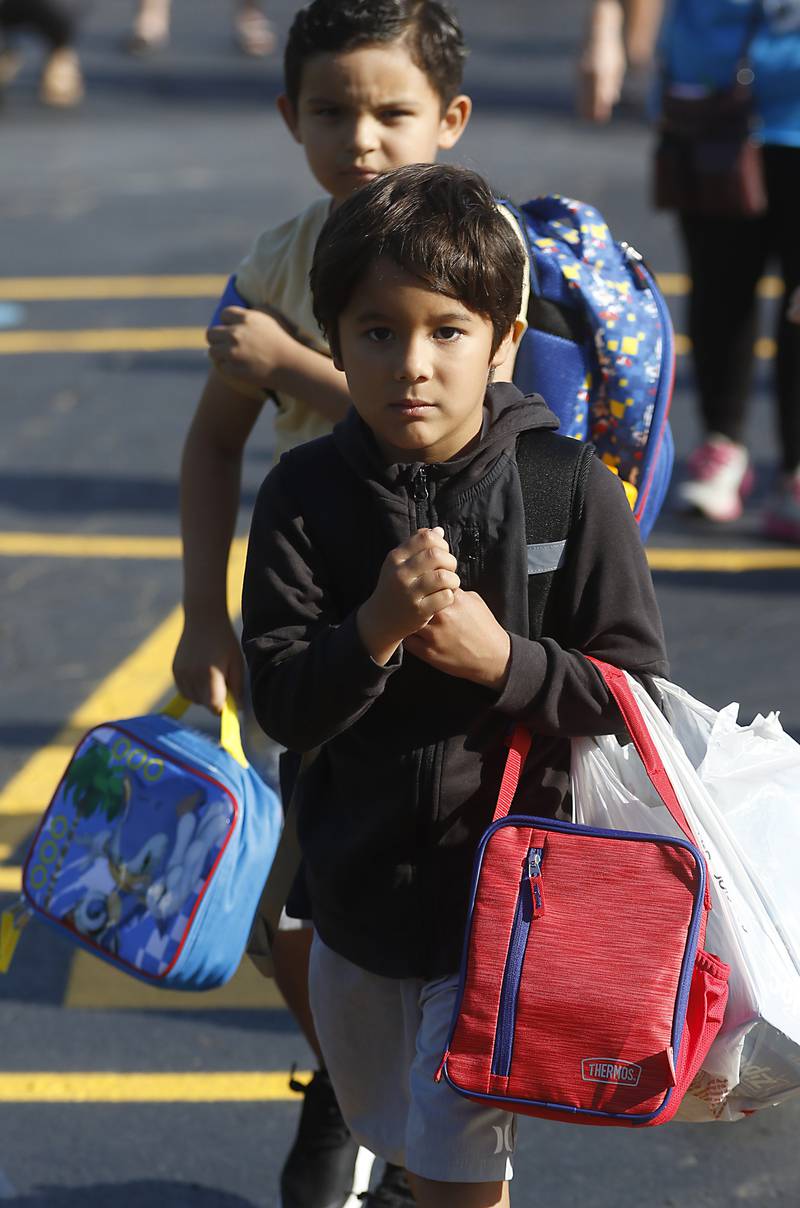 Second grader Isaac Suarez, 7, walks towards the school on he first day of school at West Elementary School in Crystal Lake on Wednesday, Aug. 16, 2023.