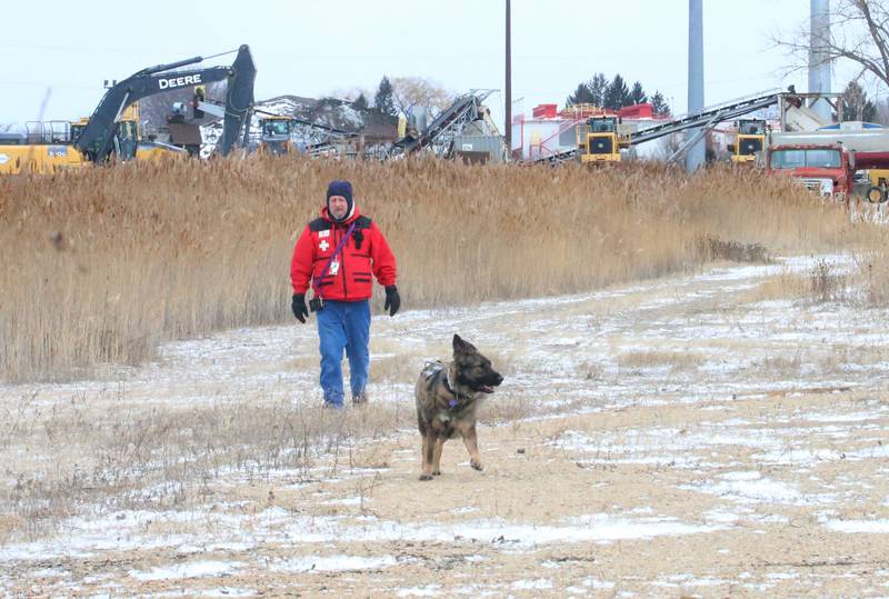 Jamie Piano, with Central K9 Search and Rescue in Spring Valley, searches the lot of Advanced Asphalt with K-9 rescue dog Zena on Wednesday, Jan. 14, 2026 in Utica. The search was for Villa Herrera who went missing on Monday. Herrera, was last seen after being involved in a crash at the Utica roundabout on Sunday. He was last spotted walking on foot and wearing a white an grey windbreaker jacket and jeans.