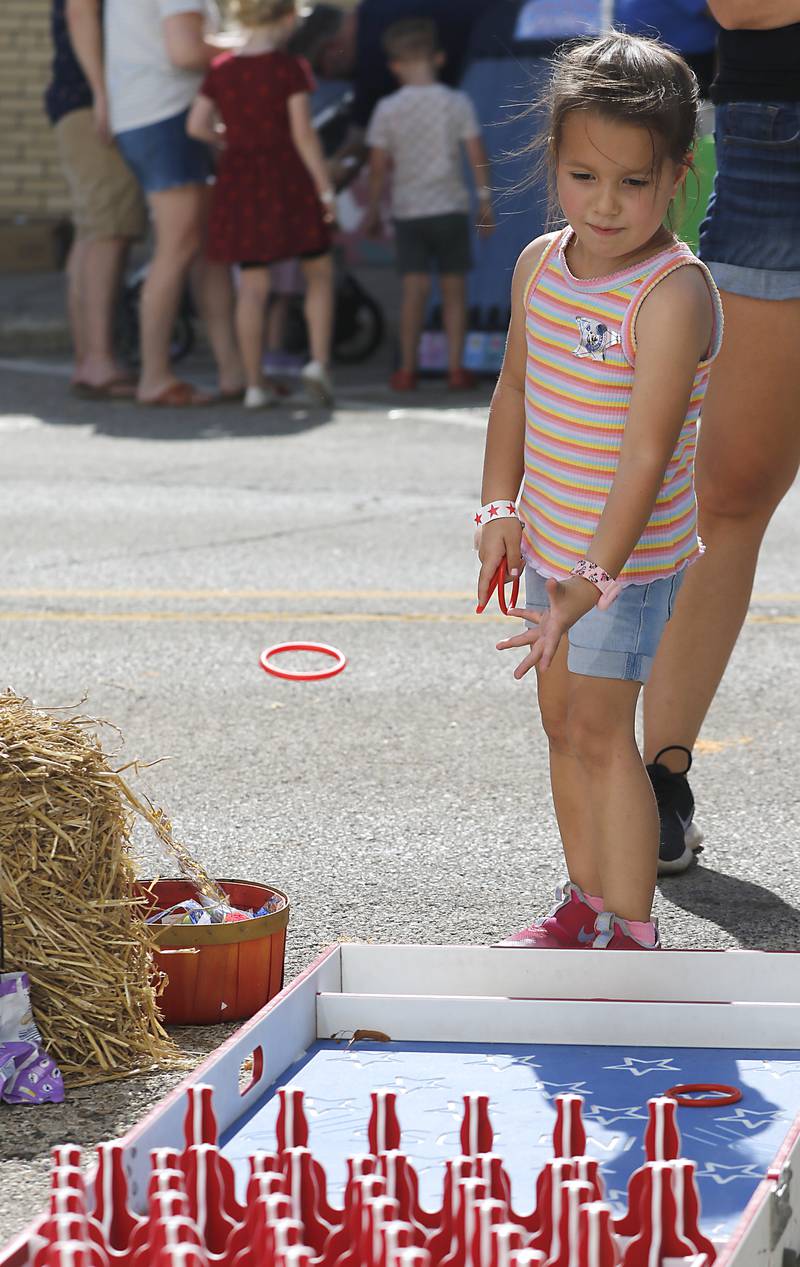 Haily Brewer4 of Lake in the Hills, tosses a ring as plays the ring toss game during the Johnny Appleseed Festival on Saturday, Sept. 27, 2025, in downtown Crystal Lake. The festival featured live performances, food and family-friendly activities.