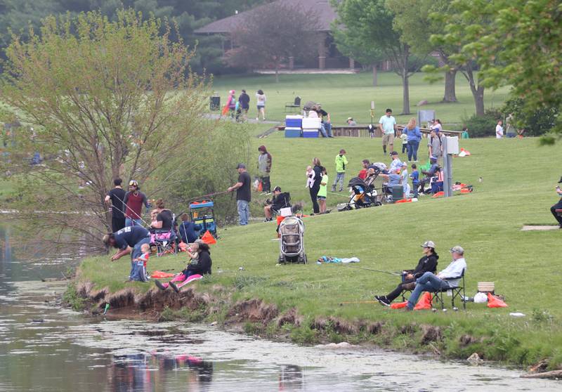 People fish during the twenty-third annual Kids Fishing Expo on Saturday, May 13, 2023 at Baker Lake in Peru.